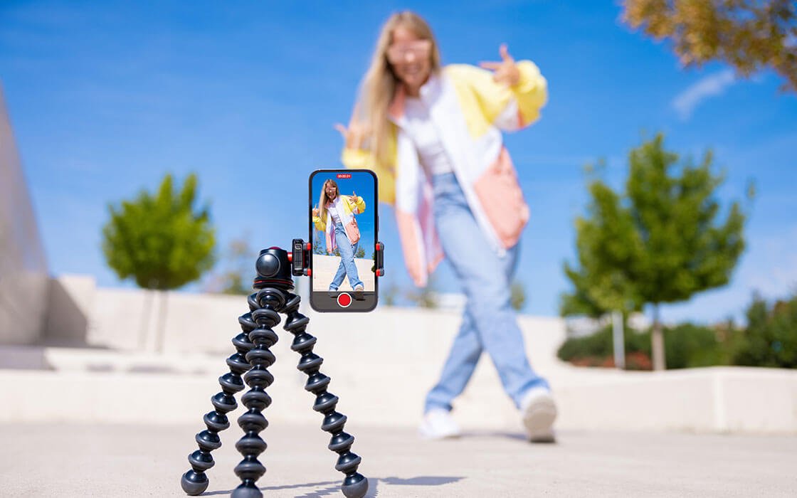 "Eine Influencerin läuft über eine asphaltierte Fläche in einem Park und nimmt dabei ein Video auf" Eine Influencerin läuft über eine asphaltierte Fläche in einem Park und nimmt dabei ein Video auf